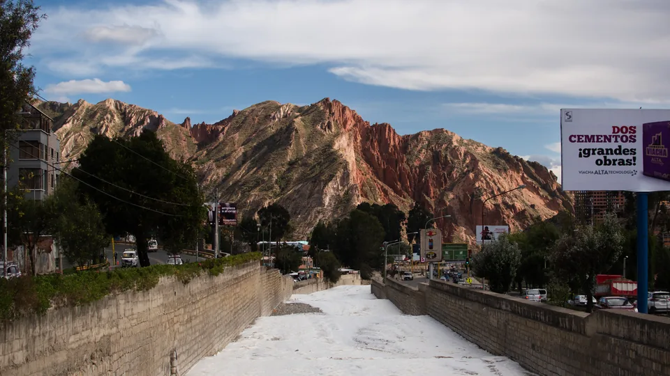A town street beneath colourful rocky mountains